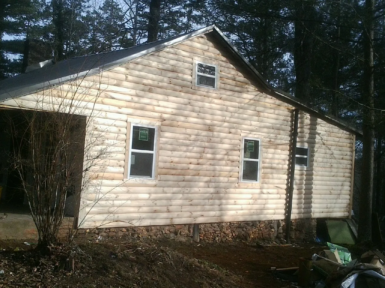 New log siding and dark metal roofing on a gable end in West Granby