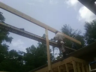 Carpenter setting a ridge beam over a new addition frame — Ice Dam Removal by Roofing Brothers in West Granby