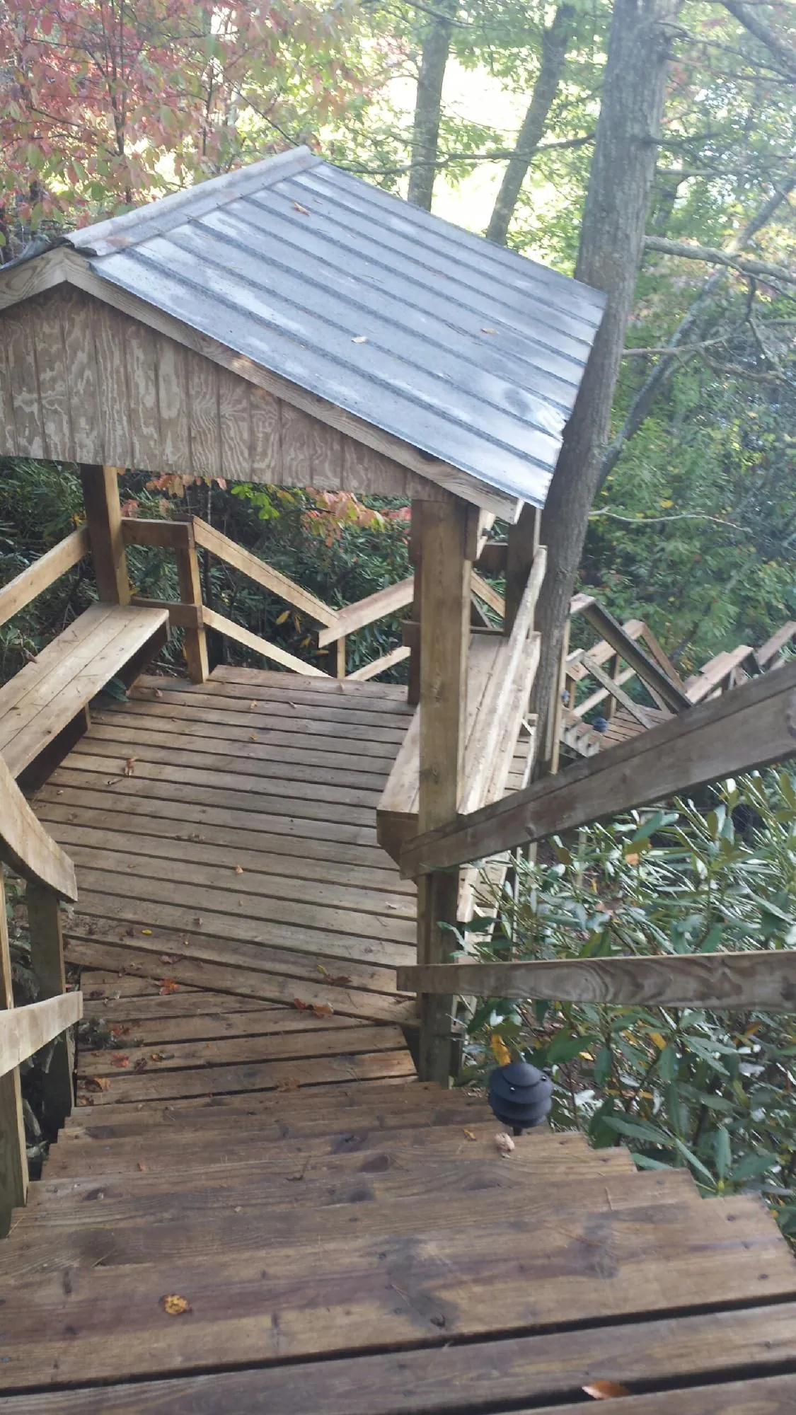 Metal roofed shelter over wooden steps on a wooded walkway — Skylight Repair & Installation work by our crew in West Granby