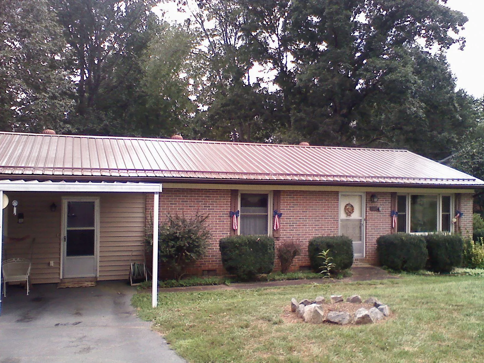 Bronze metal roof and carport on a brick ranch home — Roof Repair work by our crew in West Granby